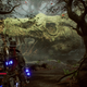 A cowboy in a dark trench coat stares at a large, dead monster.